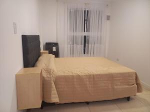 een bed met een doos in een kamer met een raam bij Apart272 in Río Cuarto