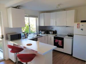 cocina con armarios blancos y nevera blanca en Private Room in a 3-Bedroom Apartment-3 en Canberra