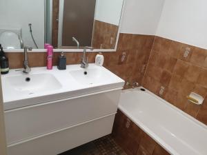 een badkamer met een wastafel, een spiegel en een bad bij Private Room in a 3-Bedroom Apartment-3 in Canberra