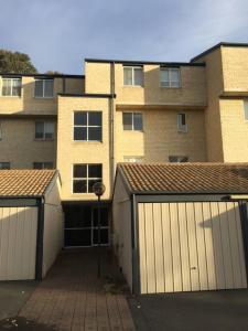 duas garagens em frente a um grande edifício de tijolos em Private Room in a 3-Bedroom Apartment-3 em Canberra