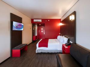 a hotel room with a bed and a flat screen tv at Ramada Encore by Wyndham Puebla in Puebla