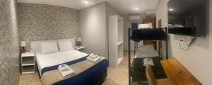 um pequeno quarto com uma cama e uma televisão em GoodStay São Paulo Ibirapuera em São Paulo