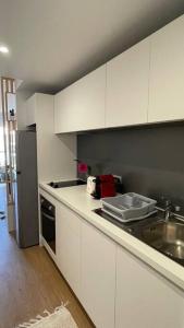 a kitchen with white cabinets and a sink at F1 standing vue mer Anse Vata in Noumea