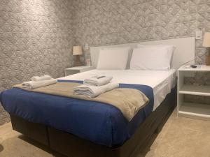 a bedroom with a large bed with towels on it at GoodStay São Paulo Ibirapuera in Sao Paulo