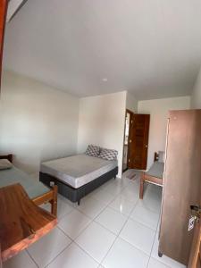 ein Schlafzimmer mit einem Bett und einem Stuhl darin in der Unterkunft POUSADA ORTEGA in Bodoquena