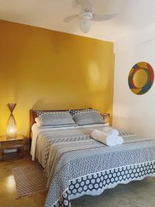 1 dormitorio con 1 cama con pared amarilla en Casas loft em Armação dos Búzios, en Búzios