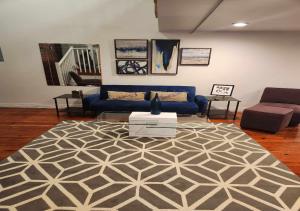 a living room with a blue couch and a rug at Detroit Loft Fort Pontchartrain in Detroit