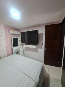 1 dormitorio con 1 cama y TV de pantalla plana en Lindo departamento en conjunto multifamiliar, en Barranquilla