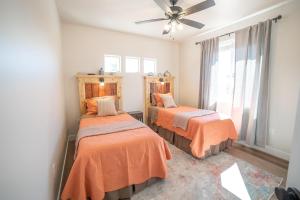 a bedroom with two beds and a ceiling fan at Searchers Hideaway at Kabab - New West Properties in Kanab