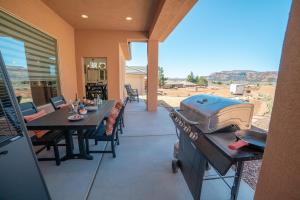 a patio with a grill and a table and chairs at Searchers Hideaway at Kabab - New West Properties in Kanab