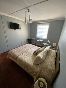 sypialnia z dużym łóżkiem i stołem w obiekcie Central y Tranquilo alojamiento w mieście Villa Alemana