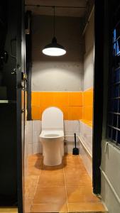 uma casa de banho com WC num quarto com azulejos laranja em Apartment Near Indiranagar Metro Station. em Bangalore