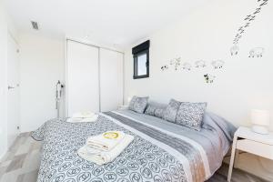 a white bedroom with a bed with towels on it at D.O.M.A. Residencial Alegria in Torrevieja
