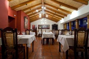 a dining room with tables and chairs with white tablecloths at Hotel Marqués De Tojo in Purmamarca