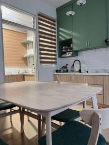 a white table in a kitchen with green cabinets at The Halt Putrajaya in Putrajaya