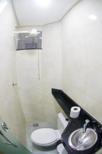 a bathroom with a toilet and a sink at Modelo flat apartamento 603 in Manaus