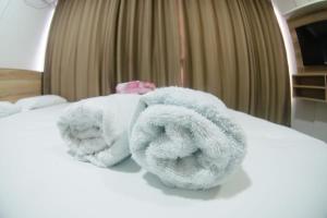 a pile of towels sitting on top of a bed at Modelo flat apartamento 603 in Manaus