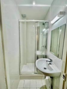 ein weißes Bad mit einer Dusche und einem Waschbecken in der Unterkunft Room Private next to Train B 100meter, easy go to Centre Ville, not whole appartement in Cachan