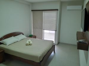 um quarto com uma cama com dois sapatos em Elegante departamento en Equipetrol em Santa Cruz de la Sierra