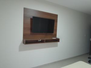 uma televisão de ecrã plano numa parede num quarto em Elegante departamento en Equipetrol em Santa Cruz de la Sierra