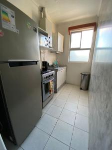 uma cozinha com geladeira e fogão em Central y Tranquilo alojamiento em Villa Alemana