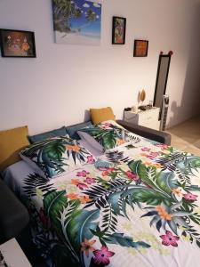 a bed with a colorful bedspread with flowers on it at Studio Marina pointe du bout vue sur le port in Les Trois-Îlets
