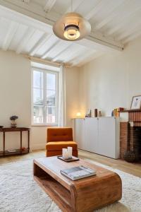 a living room with a chair and a coffee table at Maison Maliott in Colleville-sur-Mer