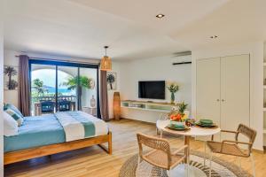 1 dormitorio con 1 cama y 1 mesa con sillas en Orient bay - Apartment Oceanview - Alamanda beach residence, en Orient Bay