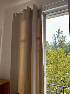 ein Fenster mit Vorhängen und Blick auf einen Baum in der Unterkunft Room Private next to Train B 100meter, easy go to Centre Ville, not whole appartement in Cachan