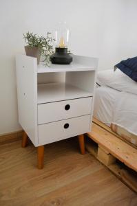 a white dresser with a candle on it next to a bed at Loft Paraiso Vintage in Bogotá