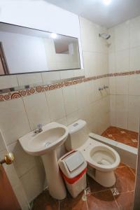 a bathroom with a toilet and a sink at Hotel D'Gloria in Churín