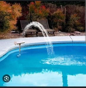 a swimming pool with a water fountain in a yard at Pattaya inn By Thai Smile in Pattaya