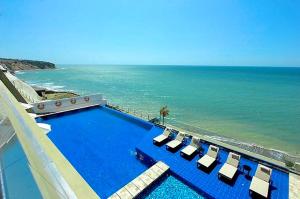 マンタにあるThe Best Luxury Penthouse - Beach Viewのラウンジチェア付きのスイミングプールと海