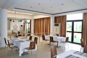 a dining room with white tables and chairs at BLUEBAY HOTEL ABIDJAN in Abidjan