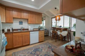 a kitchen with wooden cabinets and a table and a dining room at Beach Shack in Huntington Beach
