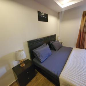 ein Schlafzimmer mit einem Bett und einer Lampe auf einem Nachttisch in der Unterkunft Private 1-Bedroom Apartment in Rawalpindi