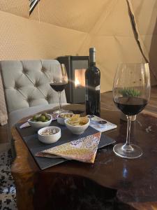 - une table avec 2 verres à vin et une bouteille de vin dans l'établissement Alma Andina, à Puelo