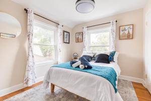 a bedroom with a bed and two windows at Classic Brick House 4BR 3BA Perfect for Families Near DC in Arlington