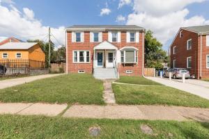 a brick house with a white door on a street at Classic Brick House 4BR 3BA Perfect for Families Near DC in Arlington