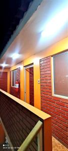 La salle de bains est pourvue d'un mur en briques et de fenêtres. dans l'établissement Hostal Arica 2, à Arica