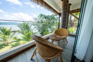balcón con 2 sillas y vistas al océano en Las Hamacas Hotel, en Sauce