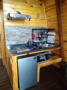 a kitchen with a stove and a sink in a cabin at Villas Margarita, Mazamitla, Jalisco. in Mazamitla