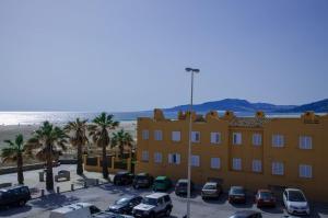 un edificio con coches aparcados en un aparcamiento junto a la playa en Apartamento Los Lances II, en Tarifa