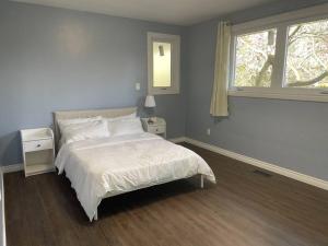 1 dormitorio con cama blanca y ventana en Country living, relax, fun., en Hamilton