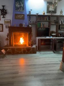 a living room with a fireplace and a television at Rural House to take a Break, La Serreria 25 in Tacoronte