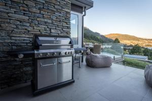 a outdoor kitchen with a stove and a stone wall at The Views and Spa by Staysouth in Queenstown