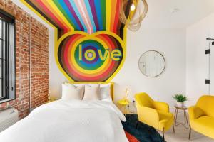a bedroom with a bed and a colorful love sign on the wall at The Acoma House in Denver