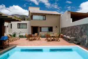 a villa with a swimming pool in front of a house at Hotel Marqués De Tojo in Purmamarca