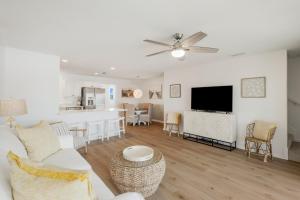 uma sala de estar com um sofá branco e uma cozinha em Sand Buckets Unit C, Ocean View Beach Townhouse em Mexico Beach