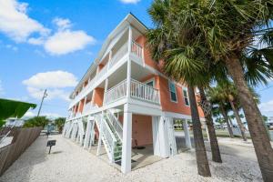 ein großes Gebäude mit Palmen davor in der Unterkunft Sand Buckets Unit C, Ocean View Beach Townhouse in Mexico Beach